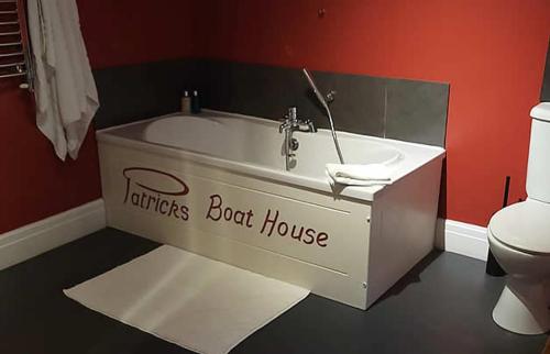 a bath tub in a bathroom with a toilet at Patricks Boathouse in Swansea