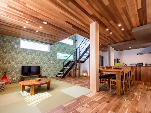 cocina y comedor con escalera y techos de madera en Kawaguchiko Villa FJ Resort, en Fujikawaguchiko