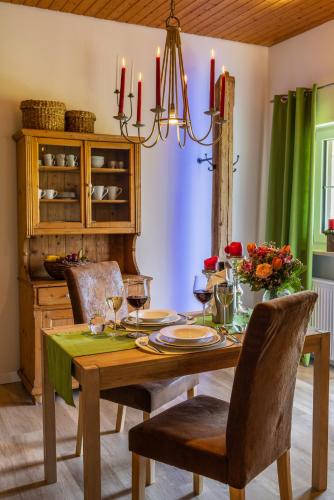 a dining room with a table with chairs and a chandelier at Ferienwohnung Hörndlwand Ruhpolding in Ruhpolding