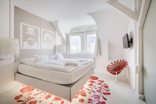 a white bedroom with a bed and a window at Butik Apartments, by BQA in Budapest