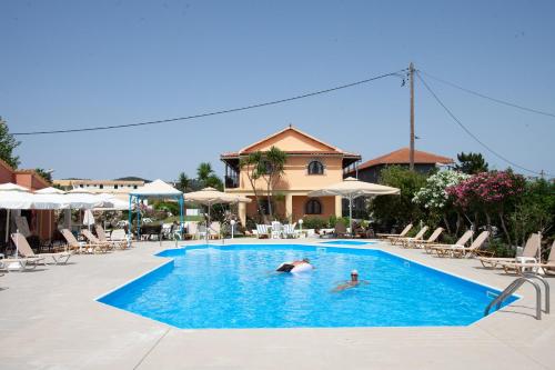 two people in a swimming pool at a resort at Lord Complex in Agios Georgios