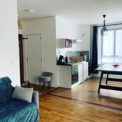 une cuisine et un salon avec un canapé et une table dans l'établissement Logement 8 personnes à St Aignan centre, à Saint-Aignan