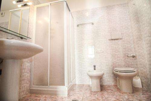 a bathroom with a shower and a toilet and a sink at Residence Corte del Bosco in Garda