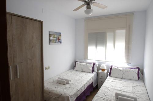 ミアミ・プラトーヤにあるCasa Carmen 2の小さなベッドルーム(ベッド2台、窓付)