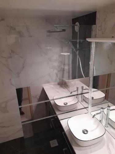 une salle de bain avec deux lavabos sur un comptoir dans l'établissement DUPLEX CAP D AGDE PISCINE, au Cap d'Agde