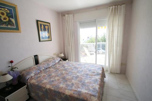 ミアミ・プラトーヤにあるApartamento Las Calasのベッドルーム1室(ベッド1台、大きな窓付)