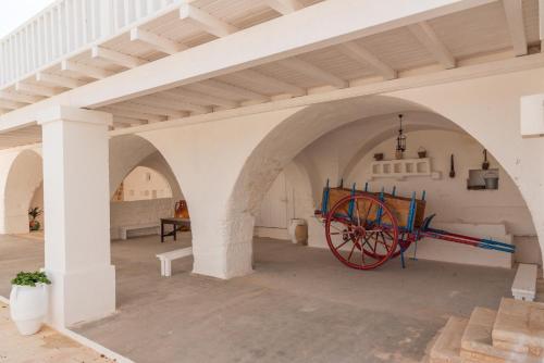 a large room with an archway with a red wagon in it at MASSERIA SCALEDDA in Manduria
