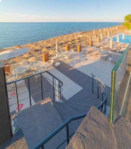 a beach with chairs and tables and the ocean at Atik Hotel in Unye