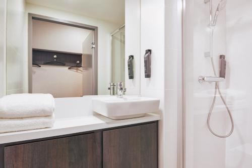 a bathroom with a sink and a shower at easyHotel Paris Charles de Gaulle Villepinte in Tremblay-En-France