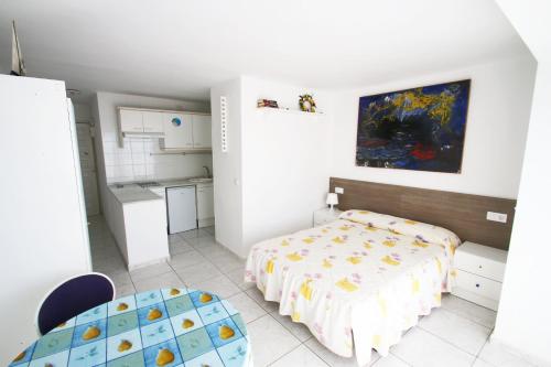 ミアミ・プラトーヤにあるEstudio 7の小さなベッドルーム(ベッド1台付)、キッチンが備わります。