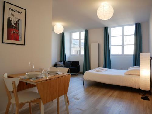 une chambre avec un lit et une table et une salle à manger dans l'établissement Offre Spéciale - Appartement coup de cœur, à Nantes