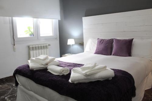 a bedroom with a large bed with towels on it at La Corredera in Úbeda