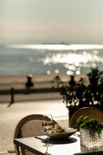 a table with a plate of food and a glass of wine at Daios Luxury Living in Thessaloniki