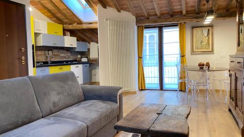ein Wohnzimmer mit einem Sofa und einem Tisch in der Unterkunft La vecchia casa di moda in Cortona