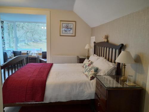 オーバンにあるエルダースリー ゲスト ハウスのベッドルーム1室(赤毛布付きの大型ベッド1台付)