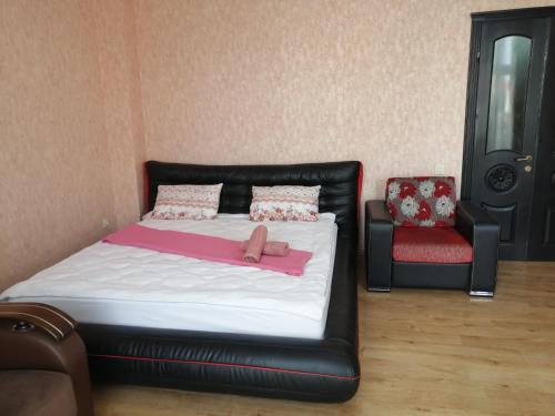 1 dormitorio con 1 cama y 1 silla roja en Apartments in the historical center of Batumi, near the seaside park en Batumi
