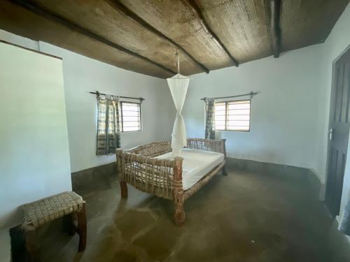 a bedroom with a bed and two windows at ShambaZuri in Gede