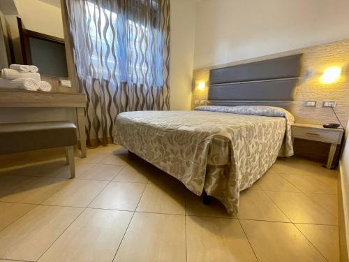 a bedroom with a bed and a desk and a sink at Villa Adriana Hotel in Tivoli