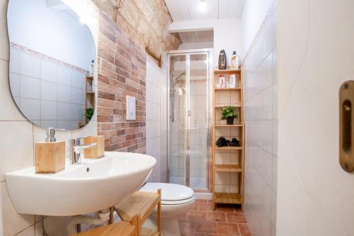 łazienka z umywalką, toaletą i lustrem w obiekcie La Casuccia Cosy Flat in Old Center w mieście Bari