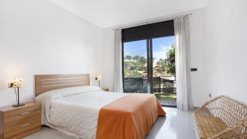 a bedroom with a bed and a large window at 2Sant - Lloret de Mar in Lloret de Mar