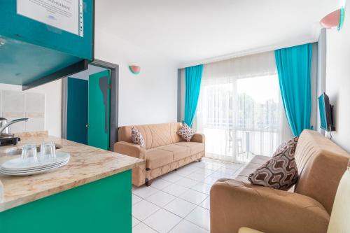 Una cocina y una sala de estar con un sofá y una mesa. en Interconti Apartments, en Marmaris