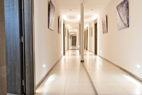 a corridor in a building with white walls and white tile floors at SALUS Locazione Turistica in Verona