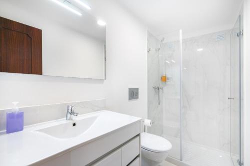 a white bathroom with a sink and a shower at WHome Beco Patacas Perfect location to explore Lisbon in Lisbon