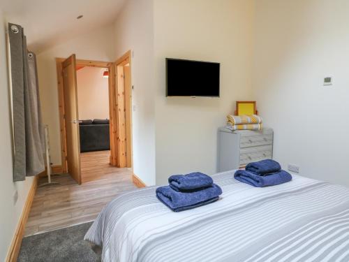 a bedroom with a bed with two blue towels on it at Pipistrelle in Stoke on Trent