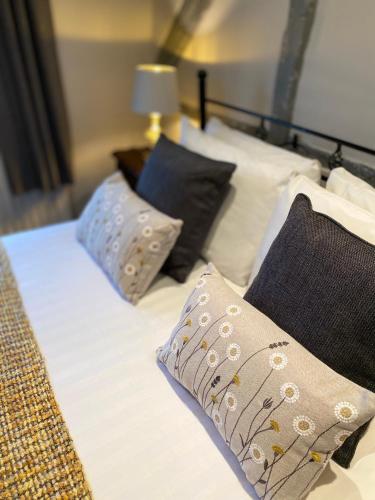 a bed with three pillows on top of it at White Hart Hotel in Dorchester on Thames