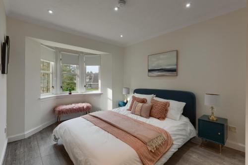 a bedroom with a large bed and two windows at 3 bedroom Windsor Garden apartment by Gleneagles in Blackford