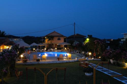 a swimming pool at night with lights around it at Lord Complex in Agios Georgios