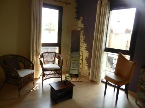 a living room with two chairs and a mirror at L'HÔTEL de CHARTRES in Chartres