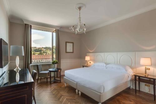 a hotel room with a large bed and a large window at Plaza Hotel Lucchesi in Florence