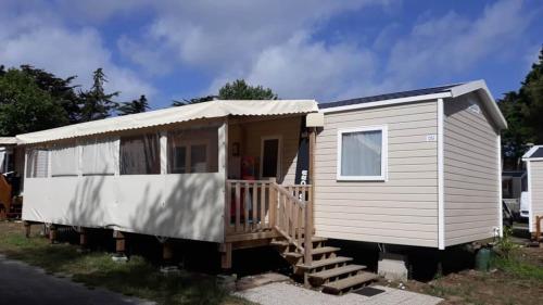 a small white trailer with a porch and stairs at Vue Mer in Quiberon