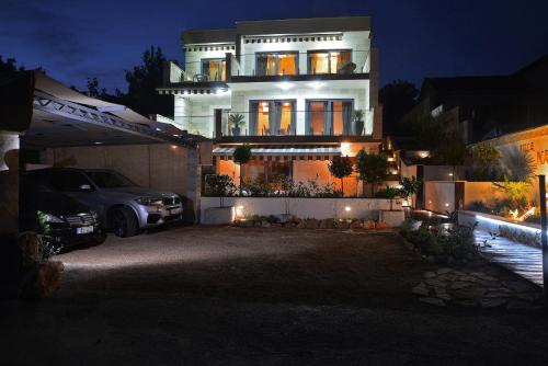 a house with a car parked in front of it at night at Villa Nature Forever in Maslinica