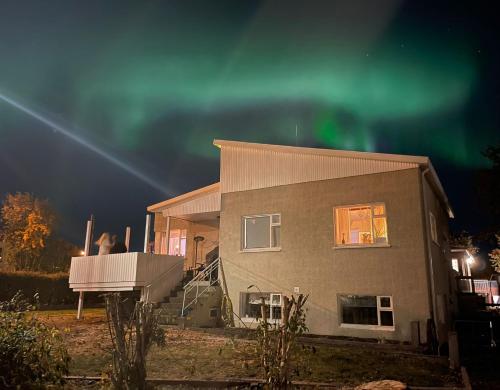 a house with the aurora in the sky at Helgimagri Apartment in Akureyri