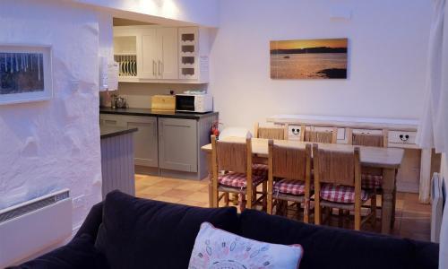 a living room and kitchen with a table and chairs at Ballyvaughan Cottages in Ballyvaughan