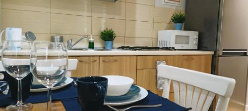 - une table avec des verres à vin et des assiettes dans la cuisine dans l'établissement Apartament Granatowy Świętoduska 12, à Lublin