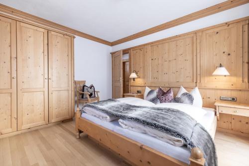 a bedroom with a large bed with wooden cabinets at Wellnessappartements Margit in Alpbach