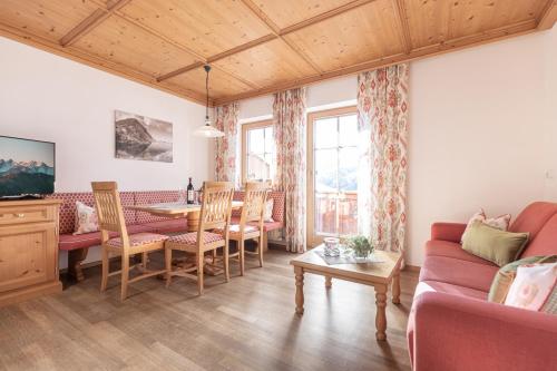 ein Wohnzimmer mit einem Tisch, Stühlen und einem Sofa in der Unterkunft Wellnessappartements Margit in Alpbach