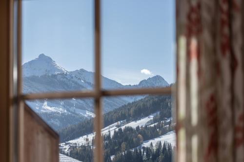 a view of a snowy mountain through a window at Wellnessappartements Margit in Alpbach