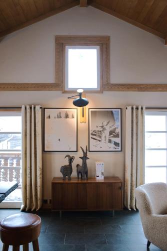 un salon avec deux animaux assis sur une table dans l'établissement Chalet du Skieur, avec services, Collection Chalets des Fermes, à Megève