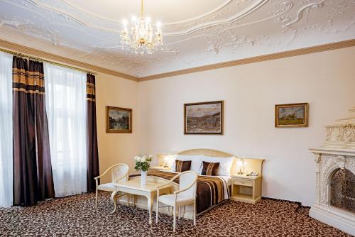 a hotel room with a bed and a chandelier at Reitenberger Spa Medical in Mariánské Lázně