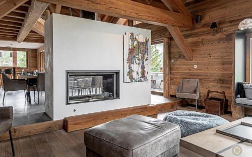 a living room with a fireplace and a table at L'Or des Cimes in Valloire