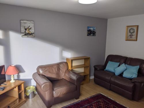 a living room with a couch and a chair at The Little Houses in Roybridge