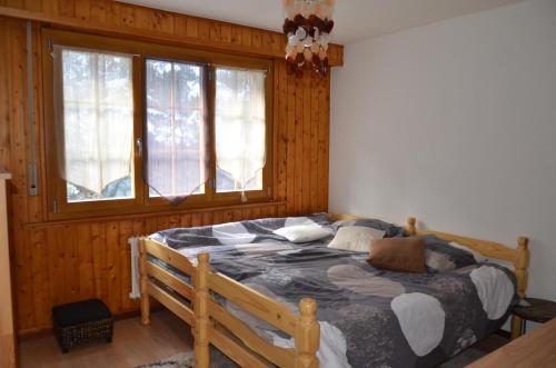 a bedroom with a large bed in a room with windows at Immeuble Les Ecureuils in Les Collons