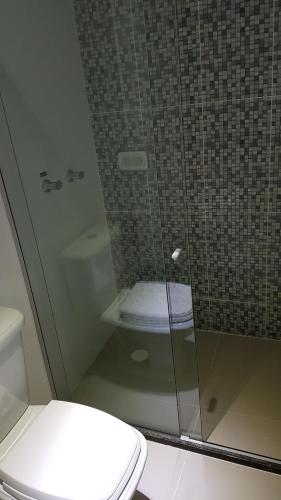 a bathroom with a glass shower with a toilet at Max Hotel in Arcoverde