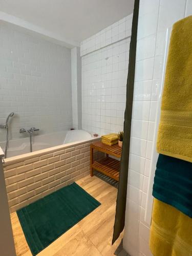 La salle de bains est pourvue d'une baignoire et d'un tapis vert. dans l'établissement Comme un Air de Provence à Blois, à Blois