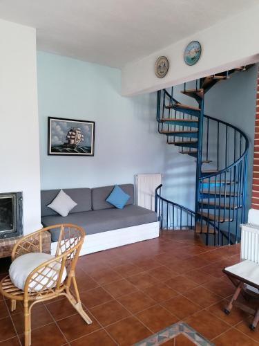 a living room with a couch and a spiral staircase at Ananias House in Karianí