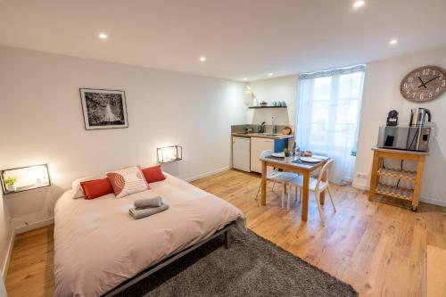 a bedroom with a bed and a desk and a kitchen at LE NID 2 QUIMPER BY Nid'Ouest in Quimper